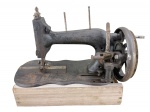 COLECIONISMO - Uma (1) máquina de costura antiga da marca CLEMENS MULLER MANUAL , de origem alemã  , confeccionada em ferro , volante lateral, engrenagens aparentes e base adaptada em madeira clara , medida : 30 x 29 x 16 cm , no estado .