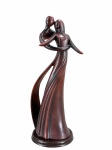ESCULTURA - Uma (1) escultura em resina representando casal em dança, em estilo moderno , com formas alongadas e acabamento em tom marrom avermelhado, apoiada sobre base circular. Medidas : 31 cm