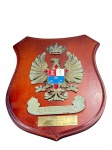 COLECIONISMO, uma (1) placa comemorativa de parede, em formato de escudo, confeccionada em madeira , com aplicação de brasão em metal patinado e esmaltado, representando águia coroada com escudo central nas cores vermelho, branco e azul, faixa inferior em relevo com inscrição referente à patrulha/Las Palmas. Acompanha placa metálica gravada A la dotación del Defensora con afecto  Las Palmas de G.C. Marzo 1989
