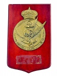 COLECIONISMO, uma (1) placa comemorativa de parede, confeccionada em madeira envernizada , com aplicação em metal dourado/patinado representando brasão da Armada Española  Grupo Alfa de la Flota, com coroa, âncora, estrela e asas em relevo. Ausência da placa inferior metálica . Medida : 29 x 18 cm