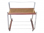 MOBILIÁRIO, uma (1) mesa para TV da década de 70 em metal e madeira, plano em fórmica e pés com rodinhas, sinais de oxidação e leves falhas, medindo 59x61x40cm.