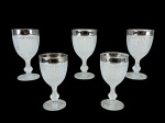 VIDRO, conjunto composto por cinco (5) taças em vidro trabalhado, com lapidação/relevo em padrão bico de jaca, haste e base decoradas e borda superior com acabamento prateado. Medida : 15,5 cm  , bordas com desgastes