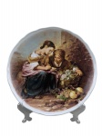 PORCELANA VIZAVI, um (1) prato decorativo confeccionado em porcelana na tonalidade branca, decorado com a reprodução da famosa pintura "Duas Mulheres na Janela" (frequentemente conhecida como "The Young Fruit Seller") do pintor barroco espanhol Bartolomé Esteban Murillo, medindo 24,5cm de diâmetro.