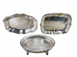METAL PRATEADO, três (3) peças confeccionadas em metal espessurado a prata, sendo: A) 1 bandeja oval com cinzelado de frisos ondulados, galeria em flores em vazados, medindo 23,5x18cm, B) 1 pãozeira da manufatura MERIDIONAL, medindo 29x20,5cm falhas na prateação e C) 1 pãozeira com recortes na borda e falhas na prateação, medindo 30x20cm.