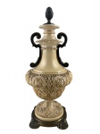 DIVERSOS, uma (1) ânfora confeccionada em resina na tonalidade creme, decorada por elementos vegetalistas em relevo, corpo torneado, base e pega da tampa representando pinha em metal dourado com sinais de oxidação, medindo 52cm de altura.