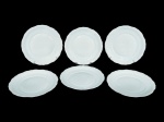 PORCELANAS, seis (6) pratos rasos confeccionados em porcelana na tonalidade branca, moldada na pasta por elementos florais e geométricos em relevo com recortes na borda, medindo 25cm de diâmetro.
