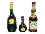 BEBIDAS, lote com três (3) garrafas, sendo: A) uma (1) garrafa de licor Liqueurs de France, da marca Marie Brizard, 70cl, 24% vol.; B) uma (1) pequena garrafa de licor/espumante Petite Liquerelle, com lacre escuro e rótulo frontal; C) uma (1) garrafa Regnier Crème de Cassis de Dijon, com rótulo ilustrado. Peças com tampas/lacres e rótulos originais, apresentando sinais do tempo, sem garantia de integridade do líquido.