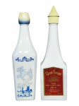 BEBIDAS, lote com duas (2) garrafas, sendo: A) uma (1) garrafa em vidro opalinado na cor branca, com decoração em azul estilo holandês, representando paisagem com moinho e tampa em formato floral e B) uma (1) garrafa Cheri-Suisse Swiss Chocolate Cherry Liqueur, em vidro na tonalidade branca, com rótulo frontal vermelho e tampa plástica em formato pontiagudo, 30% alc. Ambos abertos com pouco líquido interno, sem garantia de integridade.