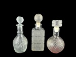 VIDROS, lote com três (3) peças, sendo 1 garrafa para whisky e 2 licoreiras, confeccionadas em vidro translucido com moldagem em bico de jaca, medindo 29cm 26cm e 24,5cm.