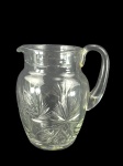 CRISTAL, uma (1) jarra confeccionada em cristal translucido com rica lapidação de palmas, caneluras, elementos geométricos e cata-ventos em baixo relevo, medindo 20,5x17x12cm.