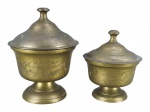 BRONZES INDIANO, dois (2) potes com tampa confeccionados em bronze indiano, cinzelado por folhagens e frisos torcidos, pega da tampa torneada, base circular cônica, maior medindo 15x10,5cm e menor 12x9cm.