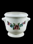 Miderâmica, um (1) cachepot confeccionado em faiança vitrificada na tonalidade branca, decorada por flores e folhagens em relevo e policromia, apresenta discretos bicados nas flores, na borda e base, medindo 15,5x20x16,5cm. (Foi fundada oficialmente em 18 de dezembro de 1941, na histórica cidade de Coimbra, Portugal. A marca desempenhou um papel notável na rica tradição ceramista portuguesa ao longo do século XX).