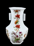 PORCELANA, um (1) vaso ânfora confeccionado em porcelana na tonalidade branca, corpo sextavado, pintura de flores e folhagens em policromia e alças laterais relevadas, medindo 21,5cm de altura, possui fio de cabelos, vide foto.