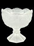 VIDRO, uma (1) cremeira confeccionada em vidro satine com moldagem de elementos florais em relevo e borda dentada, medindo 14x13,5cm.
