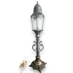 LUMINÁRIA DE MESA, DITA LANTERNA, DE INSPIRAÇÃO VITORIANA INGLESA, EXECUTADA EM METAL, POSSIVELMENTE ESPESSURADO À PRATA, POSSUINDO BASE RICAMENTE CINZELADA COM MOTIVOS FLORAIS EM RELEVO, VOLUTAS E ELEMENTOS VAZADOS, COLUNA CANELADA APLICADA COM VOLUTAS E ENCIMADA POR CÚPULA SEXTAVADA EM VIDRO LAPIDADO, MEDINDO 65 CM. APRESENTA MARCAS DO TEMPO, USO, DESGASTES, OXIDAÇÕES E/OU PEQUENAS IMPERFEIÇÕES COMPATÍVEIS COM SUA UTILIZAÇÃO E ESTADO DE CONSERVAÇÃO, CONFORME FOTOS EXTRAS