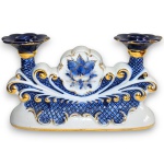 CERÂMICA SANTA TEREZINHA - CASTIÇAL DUPLO, INSPIRAÇÃO ROCOCÓ, EXECUTADO EM PORCELANA ESMALTADA E VITRIFICADA, RICAMENTE DECORADO EM RELEVOS ORNAMENTAIS COM MOTIVOS FLORAIS, VOLUTAS E DETALHES EM VIBRANTE DOURADO, CORPO CENTRAL COM MEDALHÃO FLORAL EM DESTAQUE, BASE RECORTADA E DOIS BOCAL PARA VELAS COM BORDAS ONDULADAS. MEDINDO 16,5 X 27,5 X 8 CM. APRESENTA MARCAS DO TEMPO, USO, DESGASTES NO DOURAMENTO E/OU PEQUENAS IMPERFEIÇÕES COMPATÍVEIS COM SUA UTILIZAÇÃO E ESTADO DE CONSERVAÇÃO, CONFORME FOTOS EXTRAS.