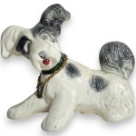 PORCELANA ROSALINO - ESCULTURA, INSPIRAÇÃO ART DÉCO, EXECUTADA EM CERÂMICA ESMALTADA E VITRIFICADA, REPRESENTANDO CACHORRO EM POSIÇÃO REPOUSADA, COM MODELAGEM ESTILIZADA E RICOS DETALHES ESCULTÓRICOS, ACOMPANHADO DE COLEIRA ORNAMENTAL METÁLICA, MEDINDO 20 X 26 X 12 CM. APRESENTA MARCAS DO TEMPO, USO, DESGASTES NA ESMALTAÇÃO E/OU PEQUENAS IMPERFEIÇÕES COMPATÍVEIS COM SUA UTILIZAÇÃO E ESTADO DE CONSERVAÇÃO, CONFORME FOTOS EXTRAS.