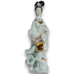 ARTE ORIENTAL - ESCULTURA EXECUTADA EM PORCELANA ESMALTADA E VITRIFICADA, COM DELICADA MODELAGEM, COM FEIÇÕES SUAVES E VESTES FLUIDAS, REPRESENTANDO DAMA TRAJANDO QUIMONO, PORTANDO CESTA FLORAL, COM RICOS DETALHES EM VIBRANTE DOURADO E APLICAÇÕES FLORAIS EM RELEVO, MEDINDO 21 CM. APRESENTA MARCAS DO TEMPO, USO, DESGASTES NO DOURAMENTO, FIOS DE CABELO E/OU PEQUENAS IMPERFEIÇÕES COMPATÍVEIS COM SUA UTILIZAÇÃO E ESTADO DE CONSERVAÇÃO, CONFORME FOTOS EXTRAS.
