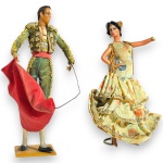 CONJUNTO DE ESCULTURAS EXECUTADAS EM MATERIAIS E TÉCNICAS DIVERSAS, COM MODELAGEM COM ELEMENTOS CÊNICOS CARACTERÍSTICOS, EXPRESSIVIDADE CORPORAL E MOVIMENTO CÊNICO COMPOSTO POR DUAS PEÇAS, SENDO: UMA, REPRESENTANDO TOUREIRO, MEDINDO 18 CM E DANÇARINA EM RICAS VESTES TÍPICAS COM APLICAÇÕES TÊXTEIS E DETALHES ORNAMENTAIS, MEDINDO 17 CM. APRESENTAM MARCAS DO TEMPO, USO, DESGASTES NOS TECIDOS, FIOS SOLTOS, PEQUENAS AVARIAS E/OU IMPERFEIÇÕES COMPATÍVEIS COM SUA UTILIZAÇÃO E ESTADO DE CONSERVAÇÃO, CONFORME FOTOS EXTRAS.
