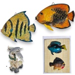 CONJUNTO DECORATIVO EXECUTADO EM MATERIAIS, TÉCNICAS, MODELOS, FORMATOS, TAMANHOS E PROCEDÊNCIAS DIVERSOS, COMPOSTO POR QUATRO PEÇAS, SENDO: GRUPO ESCULTÓRIO EM RESINA, REPRESENTANDO GOLFINHOS, MEDINDO 8 CM; PLACA DECORATIVA COM DOIS PEIXES EM RELEVO, MEDINDO 12 X 9 CM; ESCULTURA DE PAREDE EM MADEIRA, REPRESENTANDO PEIXE, MEDINDO 11 X 16,5 CM E ESCULTURA DE PAREDE EM MADEIRA, REPRESENTANDO PEIXE, MEDINDO 16 X 16,5 CM. APRESENTAM MARCAS DO TEMPO, USO, DESGASTES, PEQUENAS AVARIAS, PERDAS E/OU IMPERFEIÇÕES COMPATÍVEIS COM SUA UTILIZAÇÃO E ESTADO DE CONSERVAÇÃO, CONFORME FOTOS EXTRAS.