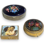 CONJUNTO DE PORTA-OBJETOS EXECUTADOS EM METAL, COMPOSTO POR TRÊS PEÇAS, SENDO: UM COM TAMPA ESMALTADA E PADRONAGEM FLORAL, MEDINDO 1,5 X 6 X 5 CM; UM COM DECORAÇÃO, REPRESENTANDO BORBOLETA E ELEMENTOS FLORAIS, MEDINDO 1,5 X 4,5 CM E UM COM TAMPA DECORADA COM CENA ROMÂNTICA, MEDINDO 1,5 X 4 X 3 CM. APRESENTAM TAMPAS ARTICULADAS, MARCAS DO TEMPO, USO, PEQUENOS RISCOS, DESGASTES, OXIDAÇÕES E/OU IMPERFEIÇÕES COMPATÍVEIS COM SUA UTILIZAÇÃO E ESTADO DE CONSERVAÇÃO, CONFORME FOTOS EXTRAS.