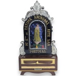 ARTE SACRA - ORATÓRIO COM CAIXA DE MÚSICA, MADE IN PORTUGAL, MARCA PLÁSTICOS LINOBELA, EXECUTADO EM MATERIAL PLÁSTICO RÍGIDO, POSSIVELMENTE GALALITE OU VINILADO, REPRESENTANDO NOSSA SENHORA DE FÁTIMA EM RESERVA CENTRAL, POSSUI PORTA ARTICULADA, INTERIOR COM MICRO LÂMPADAS PARA ILUMINAÇÃO DA IMAGEM, GAVETA INFERIOR COM DISPOSITIVO PARA ACIONAMENTO DO MECANISMO MUSICAL E APLICAÇÕES ORNAMENTAIS EM RELEVO, CONTENDO INSCRIÇÃO MÁXIMA ABENÇOAI ESTE LAR  PORTUGAL, MEDINDO 23 X 13 X 8 CM. NÃO TESTADO, SEM GARANTIAS FUTURAS. APRESENTA MARCAS DO TEMPO, USO, PEQUENOS RISCOS, DESGASTES, OXIDAÇÕES, RACHADURAS E/OU RESSECAMENTOS NO REVESTIMENTO, PEQUENAS AVARIAS E/OU IMPERFEIÇÕES COMPATÍVEIS COM SUA UTILIZAÇÃO, FUNCIONAMENTO E ESTADO DE CONSERVAÇÃO, CONFORME FOTOS EXTRAS.