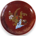 ARTE ORIENTAL - PRATO DECORATIVO EXECUTADO EM CERÂMICA ESMALTADA E VITRIFICADA, ORNADO COM CENA DE INSPIRAÇÃO ORIENTAL, REPRESENTANDO AVES ENTRE FLORES, BAMBUS E FOLHAGENS, COM RICO TRABALHO EM DOURAÇÃO, DECORAÇÃO POLICROMADA SOBRE FUNDO ESCURO, ABA DECORADA COM MOTIVOS FLORAIS ESTILIZADOS EM DOURADO, APRESENTANDO ACABAMENTO BRILHANTE, DETALHAMENTO MINUCIOSO E ASSINATURA EM SELO VERMELHO, MEDINDO 15 CM. APRESENTA MARCAS DO TEMPO, USO, PEQUENOS RISCOS, DESGASTES NA DOURAÇÃO E/OU IMPERFEIÇÕES COMPATÍVEIS COM SUA UTILIZAÇÃO E ESTADO DE CONSERVAÇÃO, CONFORME FOTOS EXTRAS.