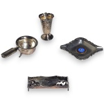 CONJUNTO, PARTE DE SERVIÇO DE MESA, EXECUTADO EM MATERIAIS, TÉCNICAS, MARCAS, MODELOS, MEDIDAS, FORMATOS, TAMANHOS, UTILIDADES E PROCEDÊNCIAS DIVERSOS., COMPOSTO POR QUATRO PEÇAS, SENDO: CINZEIRO EM AÇO INOXIDÁVEL, MARCA WOLFF, MEDINDO 10 X 11,5 CM; PALITEIRO EM METAL ESPESSURADO À PRATA, MARCA EBERLE, COM TRABALHO VAZADO E DECORAÇÃO EM RELEVO, MEDINDO 8,5 CM; COADOR EM METAL COM CABO LATERAL E APOIO, MEDINDO 3 X 11 X 6 CM E VASO EM METAL COM TRABALHO VAZADO E DECORAÇÃO EM RELEVO, MEDINDO 7 X 4,5 CM. APRESENTAM MARCAS DO TEMPO, USO, PEQUENOS RISCOS, DESGASTES, OXIDAÇÕES, PEQUENAS AVARIAS E/OU IMPERFEIÇÕES COMPATÍVEIS COM SUA UTILIZAÇÃO E ESTADO DE CONSERVAÇÃO E FALTA UM DOS PÉS DO COADOR, CONFORME FOTOS EXTRAS.