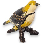 CAIXA DE JOIAS, EM ESTILO TRINKET BOX, EXECUTADA EM METAL COM ACABAMENTO ESMALTADO, DITO CLOISONNÉ, EM FORMATO DE PÁSSARO EM POSIÇÃO VERTICAL, COM DELICADA DECORAÇÃO POLICROMADA, COM O DORSO E AS ASAS RENTEMENTE CRAVADOS COM CRISTAIS LAPIDADOS, CORPO COM ARTICULAÇÃO EM DOBRADIÇA QUE SE ABRE AO MEIO, FIXADA SOBRE BASE, REPRESENTANDO GALHOS E TRONCO DE ÁRVORE, ADORNADA POR UMA DELICADA FLOR E FOLHAGENS EM RELEVO, MEDINDO 8 X 10 X 5 CM. APRESENTA MARCAS DO TEMPO, USO, PEQUENOS RISCOS, DESGASTES, PEQUENAS OXIDAÇÕES E/OU IMPERFEIÇÕES COMPATÍVEIS COM SUA UTILIZAÇÃO E ESTADO DE CONSERVAÇÃO, CONFORME FOTOS EXTRAS.