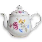 SCHMIDT - BULE PARA CHÁ, EXECUTADO EM PORCELANA ESMALTADA E VITRIFICADA, APRESENTANDO CORPO DE FORMATO BOJUDO DECORADO COM RAMOS E FLORES EM ARRANJO FLORAL NA TÉCNICA DITA DECALQUE, DOTADO DE ALÇA LATERAL E BICO SINUOSO ORNAMENTADOS COM VOLUTAS E RELEVOS, TAMPA REMOVÍVEL ENCIMADA COM PEGA HEXAGONAL CENTRALIZADA E BASE ANELAR DE PERFIL LISO, APRESENTANDO FILETES EM DOURADO APLICADOS NAS BORDAS, NO BICO, NA ALÇA E NA PEGA, MEDINDO 15,5 X 21,5 X 10 CM APRESENTANDO BICADOS NA BORDA ABAIXO DA TAMPA, ALÉM DE MARCAS DO TEMPO, USO, PEQUENOS RISCOS, DISCRETOS DESGASTES NO DOURADO PERIFÉRICO E/OU IMPERFEIÇÕES COMPATÍVEIS COM SUA UTILIZAÇÃO E ESTADO DE CONSERVAÇÃO, CONFORME FOTOS EXTRAS.
