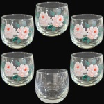 CONJUNTO DE COPOS PARA APERITIVO EXECUTADO EM VIDRO TRANSLÚCIDO, APRESENTANDO CORPO BOJUDO DECORADO COM PINTURA EM RELEVO DE MOTIVOS FITOMÓRFICOS E FLORAIS APRESENTANDO BOTÕES E ROSAS ENTRELAÇADOS POR FOLHAGENS, ASSENTADO SOBRE BASE CIRCULAR LISA, COMPOSTO POR SEIS PEÇAS, MEDINDO 5,5 X 5,5 CM CADA. APRESENTAM MARCAS DO TEMPO, USO, PEQUENOS RISCOS, MANCHAS, PEQUENOS DESGASTES E/OU IMPERFEIÇÕES COMPATÍVEIS COM SUA UTILIZAÇÃO, ESTADO DE CONSERVAÇÃO E UM DELES APRESENTA FALTA DA DECORAÇÃO, CONFORME FOTOS EXTRAS.