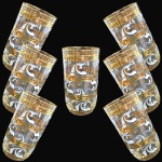 CONJUNTO DE COPOS PARA ÁGUA E/OU SUCOS EXECUTADO EM DEMI-CRISTAL, DE FORMATO CILÍNDRICO DE LINHAS DIRETAS COM BASE LEVEMENTE ARREDONDADA, APRESENTANDO CORPO DECORADO COM FRISOS HORIZONTAIS VIBRANTE DOURADO, POSSIVELMENTE FOLHAS DE OURO E VOLUTAS FITOMÓRFICAS PINTADAS, COMPOSTO POR SETE PEÇAS, MEDINDO 13 X 7 CM CADA. APRESENTAM MARCAS DO TEMPO, USO, PEQUENOS RISCOS, MANCHAS, PEQUENOS DESGASTES E/OU IMPERFEIÇÕES COMPATÍVEIS COM SUA UTILIZAÇÃO E ESTADO DE CONSERVAÇÃO, CONFORME FOTOS EXTRAS.