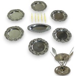 CONJUNTO, PARTE DE SERVIÇO DE MESA EXECUTADO EM MATERIAIS, TÉCNICAS, MARCAS, MODELOS, MEDIDAS, FORMATOS, TAMANHOS, UTILIDADES E PROCEDÊNCIAS DIVERSOS, COMPOSTO POR DEZOITO PEÇAS, SENDO: SEIS SOUSPLATS EM METALCOM BORDA EM RAMOS DE ROSAS, MEDINDO 10,5 CM CADA; CINCO PALITOS EM METAL, MEDINDO 11,5 CM CADA ACONDICIONADOS EM SUPORTE, MEDINDO 7 X 10 CM; GARFINHOS PARA PETISCOS EM MATERIAL PLÁSTICO, MEDINDO 8,5 CM CADA E MINI BANDEJA EM METAL, MEDINDO 13 X 7,5 CM. APRESENTAM MARCAS DO TEMPO, USO, PEQUENOS RISCOS, MANCHAS, PEQUENOS DESGASTES E/OU IMPERFEIÇÕES COMPATÍVEIS COM SUA UTILIZAÇÃO E ESTADO DE CONSERVAÇÃO, CONFORME FOTOS EXTRAS.