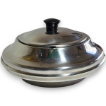 FRACALANZA - FARINHEIRA EXECUTADA EM AÇO INOXIDÁVEL, DE FORMATO CIRCULAR BOMBÊ COM REBAIXO ESCALONADO NA PARTE SUPERIOR, APRESENTANDO TAMPA ENCAIXÁVEL COM PEQUENA ABERTURA LATERAL, IDEAL PARA ACOMODAR COLHER DE SERVIÇO, ENCIMADA POR PEGA EM MATERIAL PLÁSTICO, PROVAVELMENTE BAQUELITE, MEDINDO 10 X 16 CM. APRESENTA MARCAS DO TEMPO, USO, PEQUENOS RISCOS, MANCHAS, PEQUENOS DESGASTES E/OU IMPERFEIÇÕES COMPATÍVEIS COM SUA UTILIZAÇÃO E ESTADO DE CONSERVAÇÃO, CONFORME FOTOS EXTRAS.