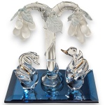 GRUPO ESCULTÓRIO EXECUTADO EM VIDRO ARTÍSTICO, TRABALHADO ARTESANALMENTE, AO GOSTO MURANO, COMPOSTO POR DUAS FIGURAS DE CISNES COM ACABAMENTO FILETADO EM VIBRANTE DOURADO, POSSIVELMENTE OURO, ÁRVORE CENTRAL DA QUAL PENDEM CACHOS DE UVAS DE ACABAMENTO ACETINADO FOSCO, APRESENTADO SOBRE BASE DE ESPELHO COM BORDAS LAPIDADAS EM BISEAUTÉ, MEDINDO 10,5 X 10 X 6 CM. APRESENTA MARCAS DO TEMPO, USO, PEQUENOS RISCOS, MANCHAS, PEQUENOS DESGASTES E/OU IMPERFEIÇÕES COMPATÍVEIS COM SUA UTILIZAÇÃO E ESTADO DE CONSERVAÇÃO, CONFORME FOTOS EXTRAS. ESCLAREÇA TODAS AS DÚVIDAS ANTES DE EFETUAR SEU LANCE, QUE SERÁ CONSIDERADO IRREVOGÁVEL E IRRETRATÁVEL. CONSULTE PREVIAMENTE OS TERMOS E CONDIÇÕES DISPONÍVEIS NO SITE. CONTATO (21) 98264-3000.
