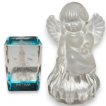 CONJUNTO DE ESCULTURAS EXECUTADAS EM VIDRO ARTÍSTICO TRABALHADO ARTESANALMENTE, COMPOSTO POR DUAS PEÇAS, SENDO: UMA, REPRESENTANDO ANJO SENTADO, COM ACABAMENTO SATINADO, MEDINDO 11,5 X 6,5 CM; E UMA EM MONOBLOCO DE VIDRO FACETADO, COM IMAGEM INTERNA DA APARIÇÃO DE NOSSA SENHORA DE FÁTIMA GRAVADA A LASER, DETALHE COLORIDO NA BASE E INSCRIÇÃO FÁTIMA, MEDINDO 6 X 4 CM. APRESENTAM MARCAS DO TEMPO, USO, PEQUENOS RISCOS, MANCHAS, PEQUENOS DESGASTES E/OU IMPERFEIÇÕES COMPATÍVEIS COM SUA UTILIZAÇÃO E ESTADO DE CONSERVAÇÃO, CONFORME FOTOS EXTRAS. ESCLAREÇA TODAS AS DÚVIDAS ANTES DE EFETUAR SEU LANCE, QUE SERÁ CONSIDERADO IRREVOGÁVEL E IRRETRATÁVEL. CONSULTE PREVIAMENTE OS TERMOS E CONDIÇÕES DISPONÍVEIS NO SITE. CONTATO (21) 98264-3000.