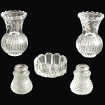 CONJUNTO, PARTE DE SERVIÇO DE MESA, EXECUTADO EM VIDRO TRANSLÚCIDO MOLDADO E LAPIDADO, COMPOSTO POR CINCO PEÇAS, SENDO: MANTEIGUEIRA E/OU PORTA-GELEIA, MEDINDO 2,5 X 5,5 CM; DOIS VASOS COM CORPOS CANELADOS, MEDINDO 8 X 4,5 CM CADA; SALEIRO EM PADRÃO BICO-DE-JACA, MEDINDO 4 X 3 CM E PIMENTEIRO EM PADRÃO BICO-DE-JACA, MEDINDO 4 X 3 CM. APRESENTAM MARCAS DO TEMPO, USO, DESGASTES E/OU IMPERFEIÇÕES COMPATÍVEIS COM SUA UTILIZAÇÃO E ESTADO DE CONSERVAÇÃO, DESTACANDO A FALTA DAS TAMPAS DO SALEIRO E PIMENTEIRO, CONFORME FOTOS EXTRAS. ESCLAREÇA TODAS AS DÚVIDAS ANTES DE EFETUAR SEU LANCE, QUE SERÁ CONSIDERADO IRREVOGÁVEL E IRRETRATÁVEL. CONSULTE PREVIAMENTE OS TERMOS E CONDIÇÕES DISPONÍVEIS NO SITE. CONTATO (21) 98264-3000.