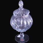 LUVIDARTE - COMPOTIÈRE SOBRE PEDESTAL EXECUTADA EM VIDRO TRANSLÚCIDO SOPRADO, COM CORPO DE FORMATO BULBOSO INTEIRAMENTE TRABALHADO EM GOMOS EM RELEVO, ASSENTADA SOBRE HASTE COM CABOCHÃO E BASE CIRCULAR LISA, ACOMPANHADA DE TAMPA ENCIMADA POR PEGA MULTIFACETADA, MEDINDO 30 X 14,5 CM. APRESENTA MARCAS DO TEMPO, USO, DESGASTES E/OU IMPERFEIÇÕES COMPATÍVEIS COM SUA UTILIZAÇÃO E ESTADO DE CONSERVAÇÃO, CONFORME FOTOS EXTRAS. ESCLAREÇA TODAS AS DÚVIDAS ANTES DE EFETUAR SEU LANCE, QUE SERÁ CONSIDERADO IRREVOGÁVEL E IRRETRATÁVEL. CONSULTE PREVIAMENTE OS TERMOS E CONDIÇÕES DISPONÍVEIS NO SITE. CONTATO (21) 98264-3000.
