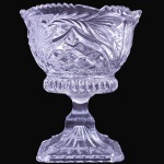 FRUTEIRA SOBRE PEDESTAL EXECUTADA EM GROSSO VIDRO TRANSLÚCIDO MOLDADO E LAPIDADO, COM CORPO DE FORMATO EVASÊ RICAMENTE DECORADO POR GRANDES FLORES SATINADAS E FOLHAGENS EM RELEVO INTERCALADAS POR LAPIDAÇÕES GEOMÉTRICAS EM FACETAS E PONTAS DE DIAMANTE, APRESENTANDO BORDA SUPERIOR ONDULADA E RECORTADA, ASSENTADA SOBRE HASTE COM ANEL FACETADO DE NOVE LADOS E ELEVAÇÃO CENTRAL CÔNICA QUE SE ADAPTA À COMPACTA BASE DE FORMATO OCTOGONAL, MEDINDO 15 X 12,5CM. PEÇA PESADA. APRESENTA MARCAS DO TEMPO, USO, DESGASTES E/OU IMPERFEIÇÕES COMPATÍVEIS COM SUA UTILIZAÇÃO E ESTADO DE CONSERVAÇÃO, CONFORME FOTOS EXTRAS. ESCLAREÇA TODAS AS DÚVIDAS ANTES DE EFETUAR SEU LANCE, QUE SERÁ CONSIDERADO IRREVOGÁVEL E IRRETRATÁVEL. CONSULTE PREVIAMENTE OS TERMOS E CONDIÇÕES DISPONÍVEIS NO SITE. CONTATO (21) 98264-3000.