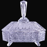 BONBONNIÈRE EXECUTADA EM CRISTAL TRANSLÚCIDO MOLDADO E LAPIDADO, COM CORPO DE FORMATO RETANGULAR DECORADO POR PADRÕES GEOMÉTRICOS, RENDILHADOS E FLORES ESTRELADAS EM RELEVO, SUSPENSO POR QUATRO PÉS RECURVOS, ACOMPANHADO DE SUA RESPECTIVA TAMPA ENCIMADA POR PEGA ALONGADA MULTIFACETADA, MEDINDO 22 X 18,5 X 13,5 CM. APRESENTA MARCAS DO TEMPO, USO, DESGASTES E/OU IMPERFEIÇÕES COMPATÍVEIS COM SUA UTILIZAÇÃO E ESTADO DE CONSERVAÇÃO, CONFORME FOTOS EXTRAS. ESCLAREÇA TODAS AS DÚVIDAS ANTES DE EFETUAR SEU LANCE, QUE SERÁ CONSIDERADO IRREVOGÁVEL E IRRETRATÁVEL. CONSULTE PREVIAMENTE OS TERMOS E CONDIÇÕES DISPONÍVEIS NO SITE. CONTATO (21) 98264-3000.