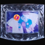 PORTA-RETRATO DE MESA EXECUTADO EM GROSSO VIDRO TRANSLÚCIDO MOLDADO, EM ESTILO LALIQUE, PODENDO SER UTILIZADO NAS POSIÇÕES HORIZONTAL OU VERTICAL, COM MOLDURA ADORNADA POR DECORAÇÃO EM RELEVO DE MOTIVOS FITOMÓRFICOS QUE SE REPETEM SIMETRICAMENTE EM TODA A SUA EXTENSÃO, MEDINDO 17 X 21,5 CM. APRESENTA MARCAS DO TEMPO, USO, DESGASTES E/OU IMPERFEIÇÕES COMPATÍVEIS COM SUA UTILIZAÇÃO E ESTADO DE CONSERVAÇÃO, CONFORME FOTOS EXTRAS. ESCLAREÇA TODAS AS DÚVIDAS ANTES DE EFETUAR SEU LANCE, QUE SERÁ CONSIDERADO IRREVOGÁVEL E IRRETRATÁVEL. CONSULTE PREVIAMENTE OS TERMOS E CONDIÇÕES DISPONÍVEIS NO SITE. CONTATO (21) 98264-3000.
