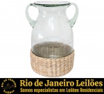 VASO, DITO ÂNFORA, EXECUTADO EM VIDRO TRANSLÚCIDO, APRESENTA CORPO BOJUDO, GARGALO REENTRANTE, DUAS ALÇAS LATERAIS EM VOLUTA E BASE REVESTIDA POR TRABALHO EM VIME TRANÇADO, MEDINDO 24 X 18 X 12 CM. APRESENTA MARCAS DO TEMPO, USO E PEQUENAS IMPERFEIÇÕES SUPERFICIAIS COMPATÍVEIS COM SUA UTILIZAÇÃO E ESTADO DE CONSERVAÇÃO, CONFORME FOTOS EXTRAS. ESCLAREÇA TODAS AS DÚVIDAS ANTES DE EFETUAR SEU LANCE, QUE SERÁ CONSIDERADO IRREVOGÁVEL E IRRETRATÁVEL. CONSULTE PREVIAMENTE OS TERMOS E CONDIÇÕES DISPONÍVEIS NO SITE. CONTATO (21) 98264-3000.