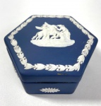 WEDGWOOD ENGLAND - CAIXA PORTA JÓIAS EM JASPER MARINHO E BRANCO COM MOTIVOS EM ESTILO NEOCLÁSSICO, MANUFATURA NO VERSO EM BAIXO RELEVO . MEDIDAS: 4 X 9 CM. CURIOSIDADES: EM 1738 COMEÇARAM AS ESCAVAÇÕES DE POMPEIA E HERCULANO PRÓXIMO DE NÁPOLES NA ITÁLIA CRIANDO A PARTIR DESSA ÉPOCA, NA EUROPA, UM NOVO INTERESSE AO ESTILO NEOCLÁSSICO. EM 1759, JOSIAH WEDGWOOD FUNDOU UMA MANUFATORA DE PORCELANA INSPIRADA EM MOTIVOS DA ANTIGUIDADE CLÁSSICA, TORNANDO SUA EMPRESA CONSAGRADA MUNDIALMENTE. AS PEÇAS ERAM REALIZADAS COM UM TIPO DE MATERIAL AO QUAL FOI DADO O NOME DE JASPER