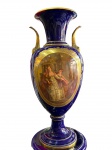 FRANÇA-SÈVRES  NAPOLEÃO III - CIRCA 1864 - RARÍSSIMA ÂNFORA EM PORCELANA DE SÉVRES - PRODUZIDA PARA CORTE  COM SELO EM VERMELHO  COM A LETRA "N" COROADA SOBRE O NÚMERO 64, CIRCUNDADA PELA INSCRIÇÃO "DÉCORÉ A SÈVRES" ESSA MARCA FAZ REFERÊNCIA DIRETA AO PERÍODO NAPOLEÃO III E AO ANO DE 1864. CENA PRINCIPAL RETRATA UMA DAMA NOBRE E JOVENS ACOMPANHANTES E CONFIDENTES, PORCELANA EM FUNDO "BLUE DE ROI" RICAMENTE ORNAMENTADA EM OURO, GUARNIÇÕES EM BRONZE ORMULU ALÇAS LATERAIS DECORADAS COM MARCARÕES FEMININOS, PROVAVELMENTE REPRESENTANDO DIVINDADES CLÁSSICAS QUE SUSTENTAM VOLUTAS ELEGANTES, A ÂNFORA REPOUSA SOBRE  ÂNFORA EM ÓTIMO ESTADO .MEDIDAS: 66 X 29 CM