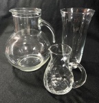 3 PEÇAS EM VIDRO SENDO JARRA GRANDE, JARRA PEQUENA E VASO. MEDIDAS: MAIOR 21 CM / MENOR 12,5 CM