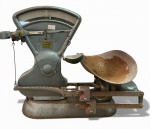 Grande balança  comercial , funcionando,  com acessórios originais, fabricada pela tradicional marca TOLEDO, utilizada em pequenas e antigas mercearias, açougues e casas de secos e molhados em meados do século XX. Estrutura em ferro fundido pintado com visor frontal em vidro curvo, escala graduada e sistema mecânico de pesagem por contrapesos deslizantes, prato lateral metálico original para apoio de mercadorias, e recipiente superior para grãos, apresenta desgaste natural do tempo, oxidações pontuais, manchas no prato e marcas de uso compatíveis com a idade. Provavelmente 1940-1960. Medidas: 69 cm de altura x 76 cm de comp.