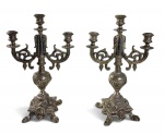 PAR DE CANDELABROS COM 3 LUMES CADA CONFECCIONADO EM METAL ESPESSO RICAMENTE PRATEADO, BASE DE SEÇÃO QUADRANGULAR RICAMENTE CINZELADA COM MOTIVOS FLORAIS, CONCHEADOS E VOLUTAS SUPORTADA POR QUATRO EXPRESSIVOS PÉS EM FORMA DE GARRA DE LEÃO ESTILIZADA. MEDIDAS: 39 X 24 CM