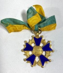 INSÍGNIA DA ORDEM DO MÉRITO MILITAR, IMPORTANTE CONFEDERAÇÃO DAS FORÇAS ARMADAS DO BRASIL. CRUZ DE CINCO BRAÇOS ( PENTAGONAL) ESMALTADA EM AZUL-REI EM AMBAS AS FACETAS, COM BORDAS EM METAL DOURADO E PEQUENAS ESFERAS NAS ESTREMIDADES D CADA BRAÇO. MEDALÃO CENTRAL CIRCULAR "AO MÉRITO" E FITA DE SEDA EM GORGURÃO COM AS CORES NACIONAIS. MEDIDAS: 3 X 4 CM