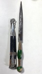 ADAGA GAÚCHA COM BAINHA TRABALHADA , CABO ORNAMENTAL BAINHA EM COURO ESCURO, PONTEIRA EM METAL PRATEADO, LAMINA COM SINAIS DE FERRUGEM. MEDIDA TOTAL:  31,5 CM / MEDIDA DA LÂMINA; 18 CM