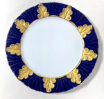 MEISSEN- PRATO EM PORCELANA DE MEISSEN, BORDA LARGA COM ACABAMENTO EM RELEVO CANELADO SOB UM RICO ESMALTE AZUL COBALTO , ROYAL BLUE, APLICAÇÃO DE SEIS FOLHAS DE CARVALHO ESTILIZADAS EM ALTO RELEVO DOURADA A FOGO, A BORDA EXTERNA APRESENTA UM DELICADO  ACABAMENTO ONDULADO E FILETADO A OURO. MEDIDAS: 19 CM DE ALT.